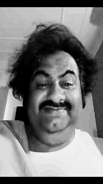 a black and white photo of a man wearing a wig and mustache .