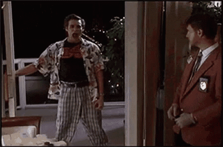 a man in a hawaiian shirt is standing in a room next to a man in a red suit .