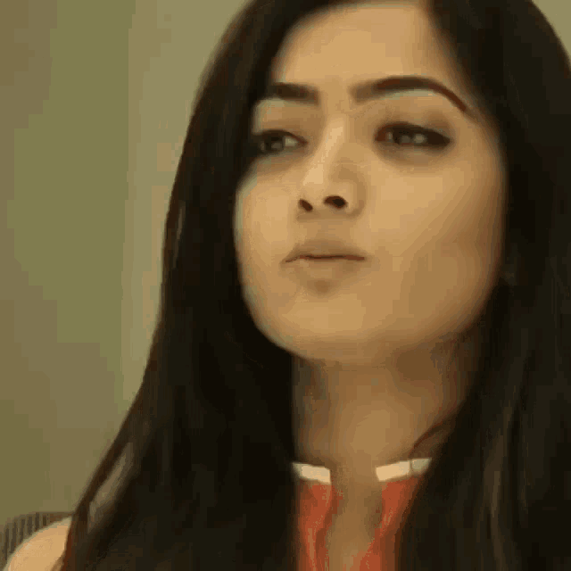a close up of a woman 's face with long black hair looking at the camera .