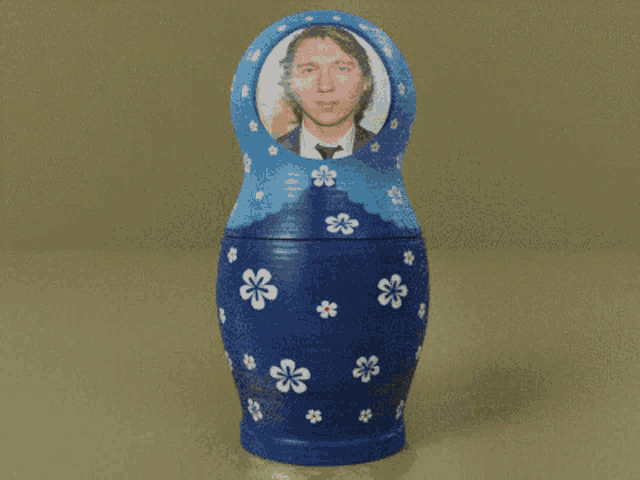 a blue nesting doll has a picture of a man in a suit on it