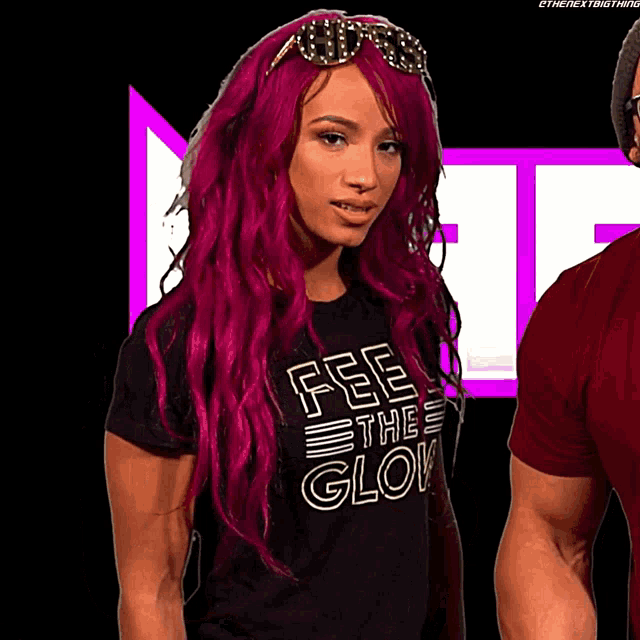 a woman with pink hair is wearing a shirt that says " feel the glow "