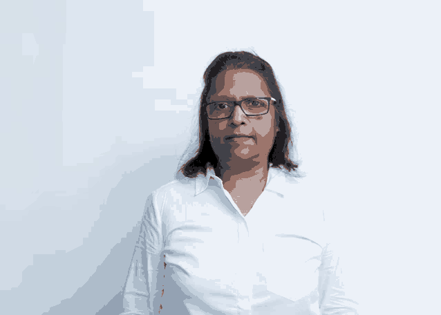a woman with glasses and a white shirt looks at the camera