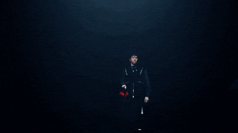 a man in a black jacket is standing next to another man in a black jacket
