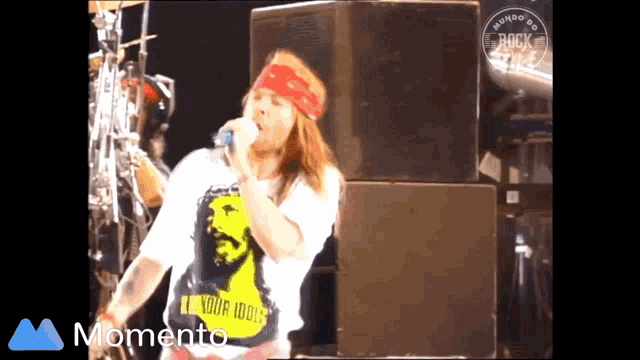a man singing into a microphone wearing a shirt that says your idols