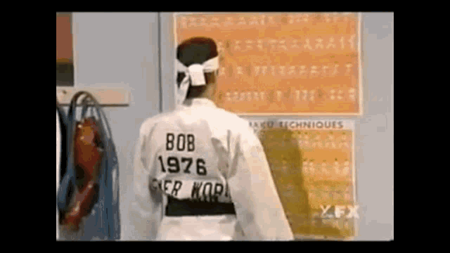 a man in a karate uniform has the year 1976 on the back of his shirt .
