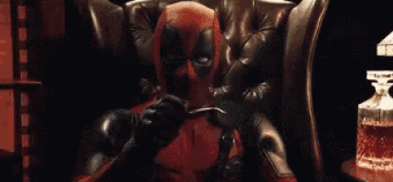 a man in a deadpool costume is sitting in a leather chair