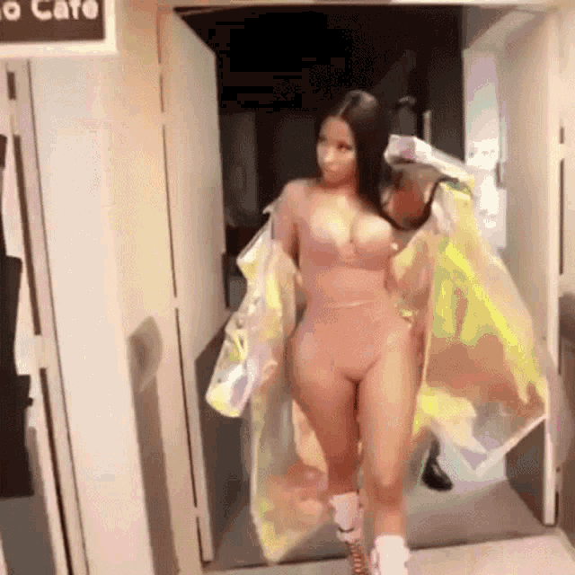 a woman in a bodysuit is walking through a doorway .