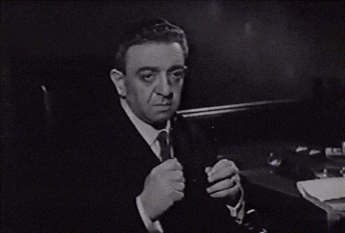 a man in a suit and tie is holding a knife