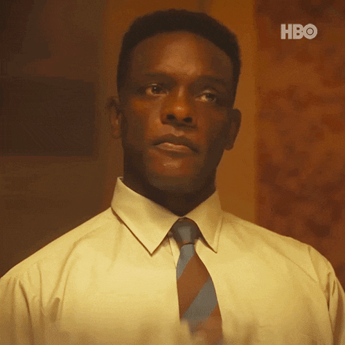 a man in a yellow shirt and blue tie is looking up at something