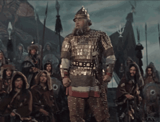 a man in armor stands in front of a crowd