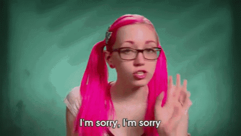 a girl with pink hair and glasses is saying i 'm sorry i 'm sorry .