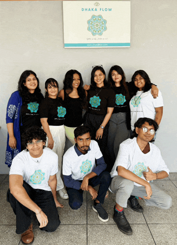a group of people posing in front of a sign that says ' dhaka flow '