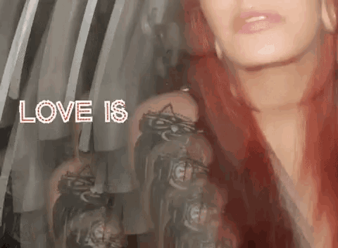 a woman with red hair is standing in front of a mirror with the words love is written above her