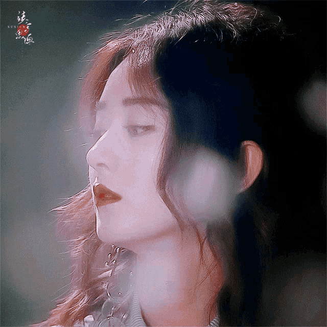 a close up of a woman 's face with red lipstick on her lips