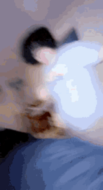 a blurry picture of a person 's face with a light coming out of their mouth .