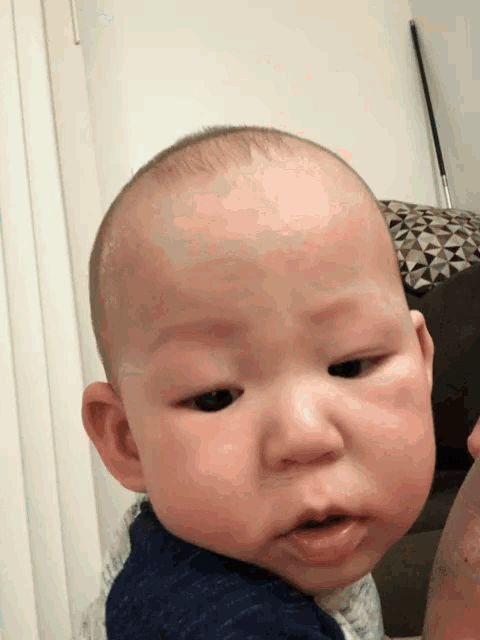 a baby with a shaved head and black eyes