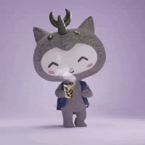 a stuffed animal with horns is holding a cup of steaming coffee