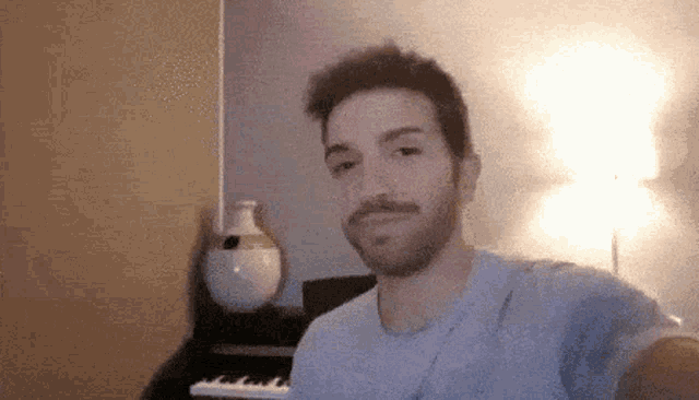 a man is taking a selfie in front of a piano .