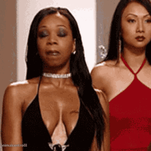 two women are standing next to each other and one has a tattoo on her chest