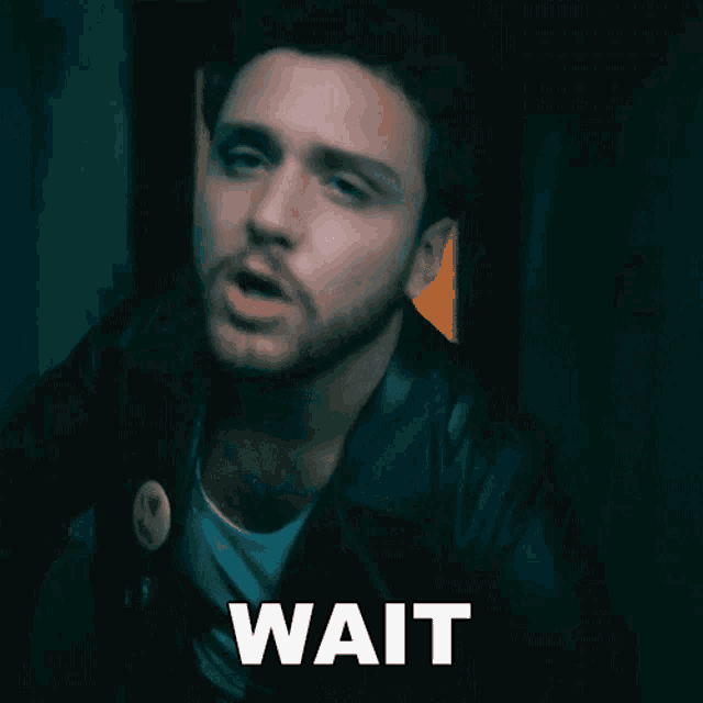 a man in a black jacket says wait in white