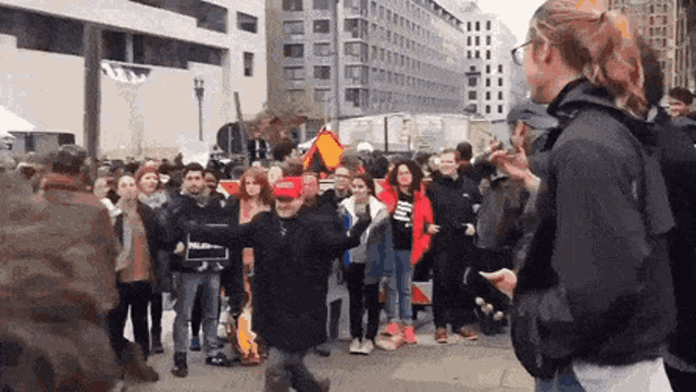 a woman stands in front of a crowd of people holding a sign that says ' a ' on it