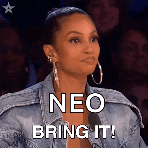 a woman wearing a denim jacket and hoop earrings says neo bring it !