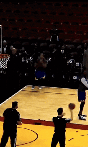 a basketball game is going on in a stadium with empty seats
