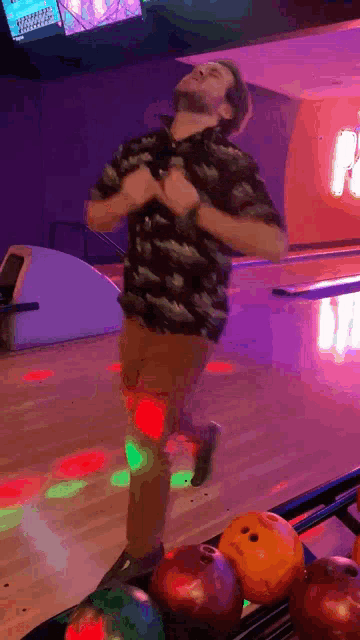 a man is dancing in a bowling alley with a sign that says paradise