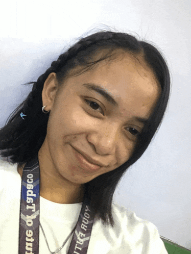 a girl wearing a lanyard that says lspsco smiles for the camera