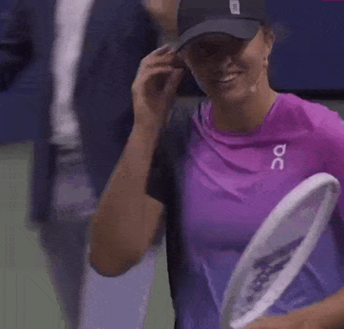a woman wearing a black hat and a purple shirt that says oc