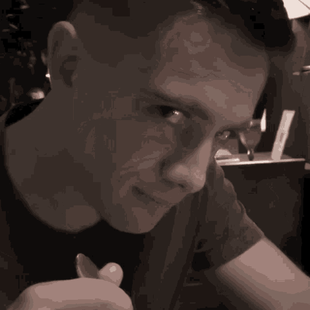 a man is smiling and looking at the camera in a black and white photo