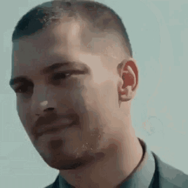 a close up of a man 's face with a beard in a suit and tie .