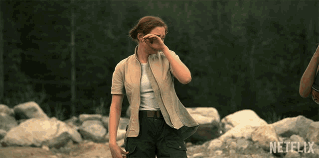 a woman is standing in a rocky area with a netflix logo in the corner