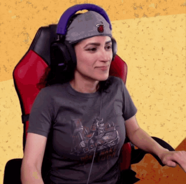 a woman wearing headphones and a miami hat sits in a red chair