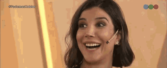a woman with braces on her teeth is smiling while wearing a microphone on her head .