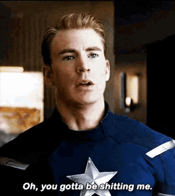 a man in a captain america uniform is talking to another man .