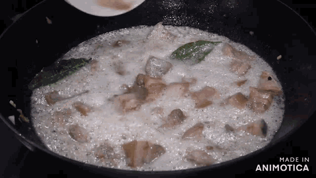 a pan of food is being cooked and the words made in animotica are on the bottom