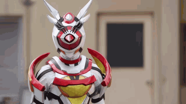 a robot with a red and white costume is standing in front of a building