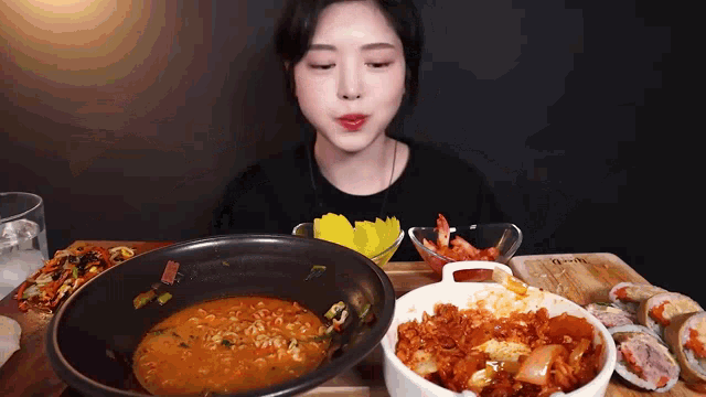 a woman is sitting at a table eating a bowl of food
