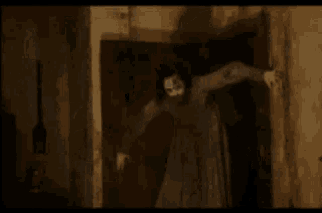 a woman in a long dress is standing in a doorway .