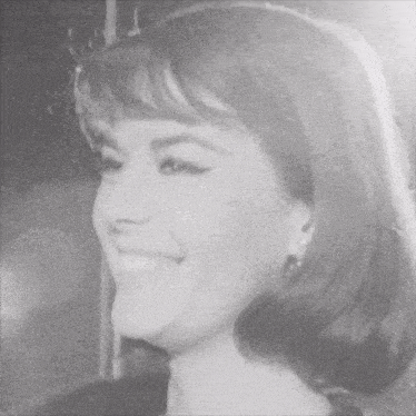 a black and white photo of a smiling woman with short hair