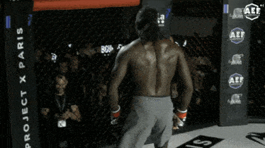 a man in a boxing ring with project x paris behind him