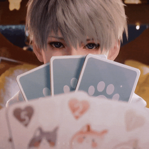 a person holding playing cards in front of their face and the word yale is on the bottom right