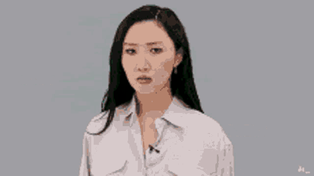 a woman in a white shirt stands in front of a green screen with numbers written on it