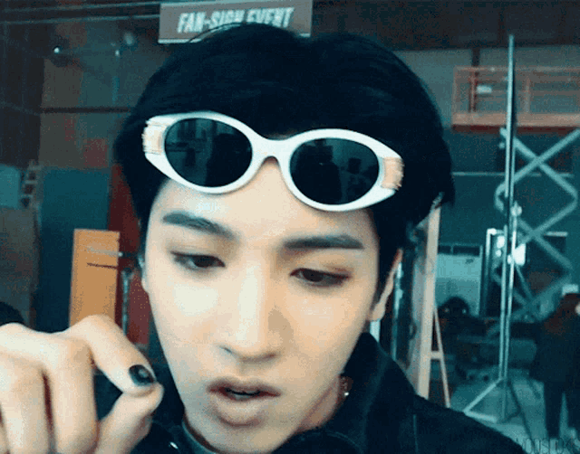 a man wearing sunglasses is talking on a cell phone