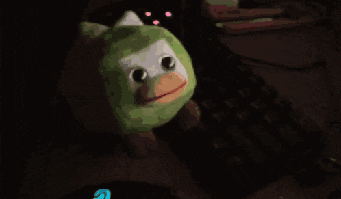 a stuffed animal sits on a desk next to a keyboard and mouse