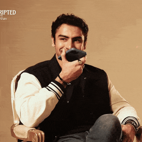 a man sitting in a chair holding a cell phone in front of his mouth with the word ripped on the bottom