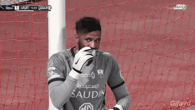 a soccer goalie holding a ball with the mbs logo in the background