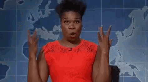 a woman in a red dress is making a surprised face while standing in front of a map .