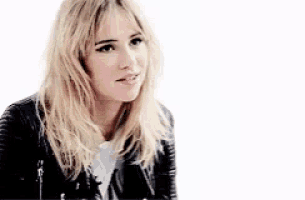 a blonde woman wearing a black leather jacket and a white shirt .
